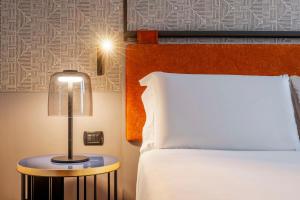 A bed or beds in a room at NH Catania Centro