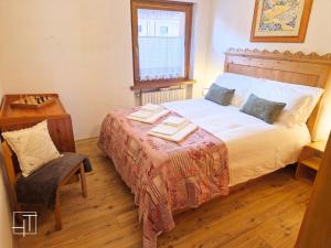 a bedroom with a bed with a table and a chair at HT - Ciasa Dahu Cortina Escape in San Vito di Cadore