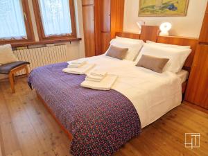 a bedroom with a large bed with towels on it at HT - Ciasa Dahu Cortina Escape in San Vito di Cadore