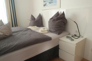 a bed with pillows and a lamp on a night stand at Hotel Merlin in Cologne