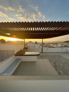 a rooftop patio with a table and a bench at Beach house Sol Mar y Relax in Cerro Azul