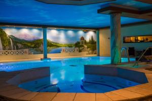 a swimming pool in a hotel with a painting on the wall at Stolberger Hof in Stolberg