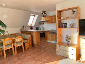 a kitchen with wooden cabinets and a table and a dining room at Finnhäuser am Vogelpark - Haus Anke in Marlow