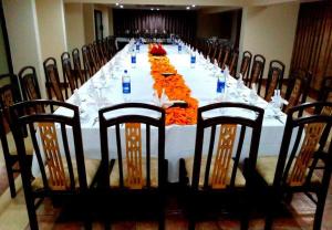 uma mesa longa numa sala com cadeiras e uma mesa longa em Hotel in Multan em Multan