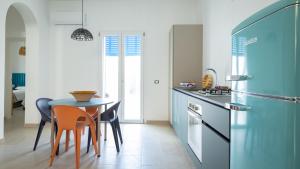 a kitchen with a table and a blue refrigerator at Casa BON BON in Triscina