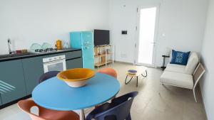 a kitchen with a blue table and chairs in a room at Casa BON BON in Triscina +10 photos
