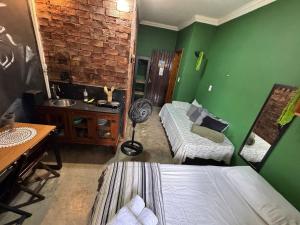 a bedroom with green walls and a bed and a desk at Flat aconchegante 1 Vila Rica ao lado Mineirão Pampulha BH in Venda Nova