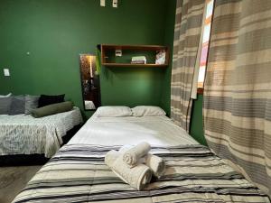 two beds in a room with green walls at Flat aconchegante 1 Vila Rica ao lado Mineirão Pampulha BH in Venda Nova