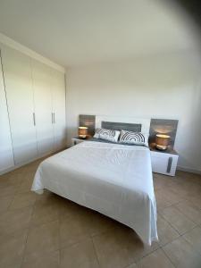 a bedroom with a white bed with two lights on it at Applause Oeiras in Oeiras