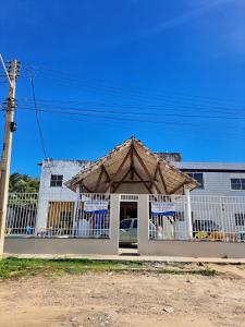 a building with a gate with a roof at Pousada leblon in Caucaia +4 photos