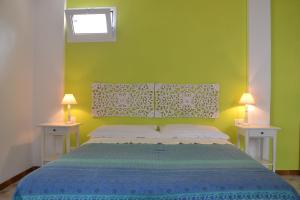 a bedroom with a bed with a green wall at B&B Talìa in Scopello