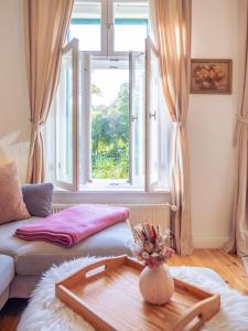 a living room with a couch and a large window at Ferienwohnung Papenmühle am Kurpark in Bad Freienwalde +29 photos