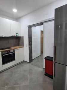 a kitchen with white cabinets and a stainless steel refrigerator at WellandHome Aalen - XXL Deluxe Apartment in Aalen +17 photos