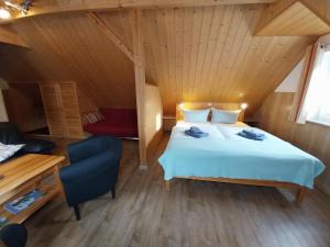 a bedroom with a bed and a chair in a room at Ferienwohnung - Landhotel Waldschlößchen in Sohland +25 photos
