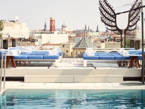 a pool with blue chairs and a view of a city at VP Plaza España Design in Madrid