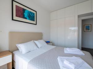a bedroom with a white bed and a mirror at Apt. dos Correios in Lagos