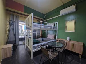 een kamer met een stapelbed en een tafel en stoelen bij Bonanza Patong Beach2 100m to Beach Green Room in Patong Beach
