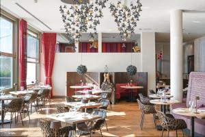 a dining room with tables and chairs and windows at Scarlet Hotel - Adults Only in Mawgan Porth