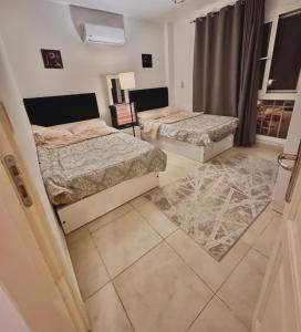 two beds in a room with two rugs at Madinaty in Madinaty