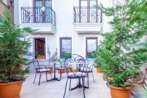 d'une terrasse avec une table, des chaises et des potiers. dans l'établissement Saba Sultan Hotel, à Istanbul