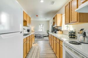 a kitchen with wooden cabinets and a white refrigerator at 3 Mi to Elephant Butte Lake Cozy Retreat! in Truth or Consequences