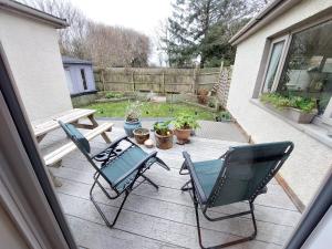 a patio with two chairs and a picnic table at South Side at The Swallows - Elegant Double Bed Apartment - & optional extra - Single Bed Cabin - Max 3 people in Bishopston