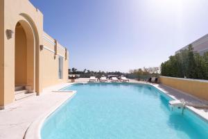 - une piscine avec des chaises sur le côté du bâtiment dans l'établissement Massive 5BR Hilltop Villa • Luxury Stay, à Hurghada