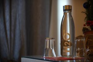 a bottle and two glasses on a table at B&B Stupor Mundi in Altamura