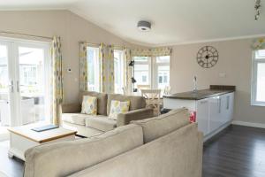 a living room with a couch and a kitchen at Croyde Bay Hotel or Self Catering in Croyde