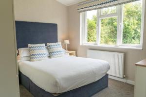 a bedroom with a large bed with two windows at Croyde Bay Hotel or Self Catering in Croyde
