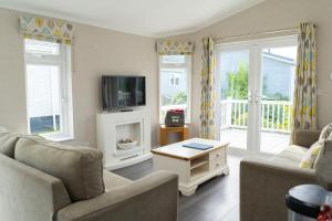a living room with two couches and a tv at Croyde Bay Hotel or Self Catering in Croyde
