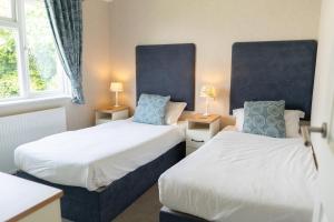 two beds sitting next to each other in a bedroom at Croyde Bay Hotel or Self Catering in Croyde