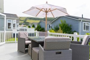 a patio with a table and an umbrella at Croyde Bay Hotel or Self Catering in Croyde