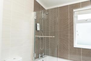 a bathroom with a shower and a tub and a toilet at Croyde Bay Hotel or Self Catering in Croyde