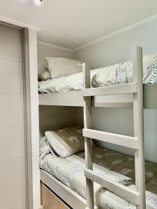 a bedroom with bunk beds with pillows on them at Lago y Volcán in Pucón +11 photos
