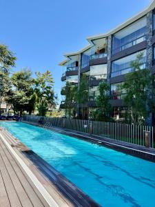 a swimming pool in front of a building at Lago y Volcán in Pucón