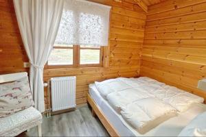 a bed in a wooden room with a window at Ferienhaus Neckar 58 in Hayingen