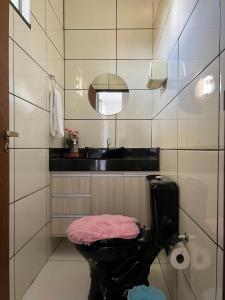 La salle de bains est pourvue de toilettes noires et d'un lavabo. dans l'établissement Apartamento Studio Climatizado, à Chapadão do Sul