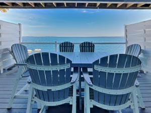 a table and chairs on a deck with the ocean at Put-in-Bay Waterfront Condo #111 in Put-in-Bay +26 photos