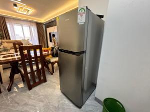 内罗毕Sunset Cosy abode的带桌子的厨房里的不锈钢冰箱