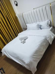 内罗毕Sunset Cosy abode的一张白色的大床，配有白色的床单和枕头 更多15张照片