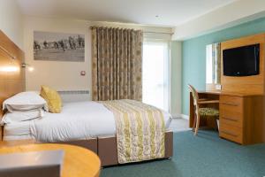 a hotel room with a bed and a desk at Croyde Bay Hotel or Self Catering in Croyde