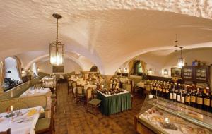 a restaurant with tables and chairs and wine bottles at Hotel Grünes Türl in Bad Schallerbach