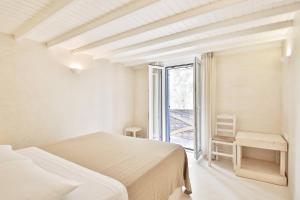 a white bedroom with a bed and a window at Baba Houlakia in Houlakia +26 photos