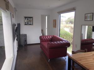 a living room with a leather couch and a window at Casa container in Mar del Plata