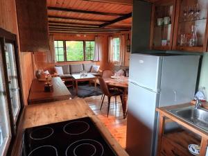a kitchen and dining room with a refrigerator and a table at charmante cabane in Rhodes