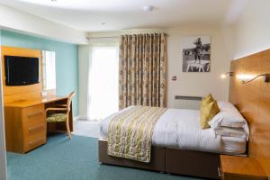 a hotel room with a bed and a desk at Croyde Bay Hotel or Self Catering in Croyde +37 photos