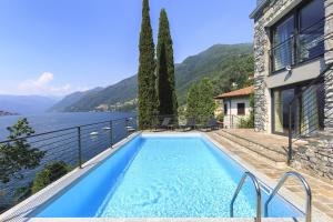 a house with a swimming pool next to the water at Villa Felicity by My Villa Collection in Riva