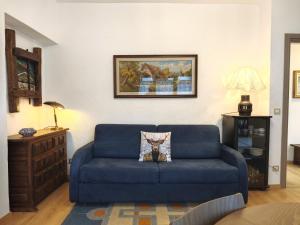 a blue couch with a pillow on it in a living room at Hostdomus - Fraiteve Suite in Sestriere