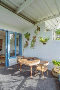 a patio with a table and chairs and plants at Pipeline - Breezy 1 Bedroom Oceanfront Apartment by Triang Villas in Tanah Lot